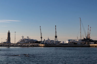 Sailboats in sea against clear sky