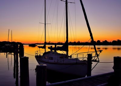 Boats at harbor during sunset