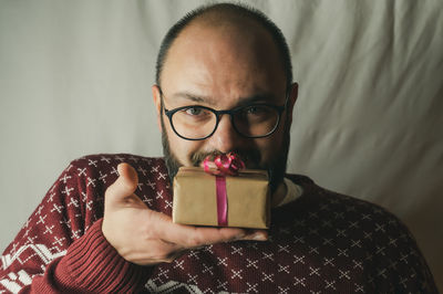 Portrait of man holding eyeglasses