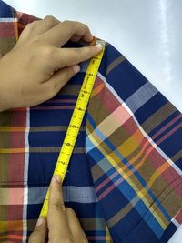 Cropped hand of woman measuring textile