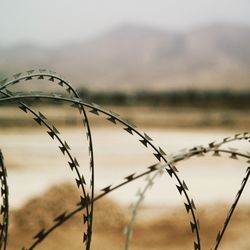 Close-up of barbed wire fence on military airfield
