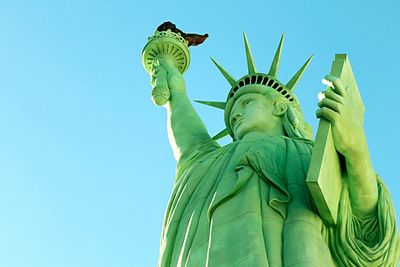 Low angle view of statue against clear blue sky