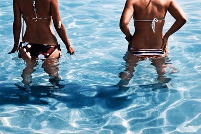 Mid section of bikini women in water