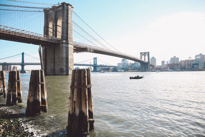 Bridge over river in city against sky