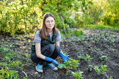 Woman works on the ground growing organic plants, fruits and vegetable