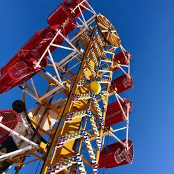 Low angle view of ferris wheel against blue sky