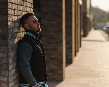 Rear view of man standing against building