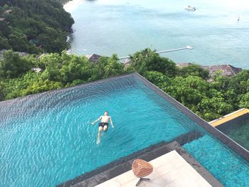 High angle view of man swimming in infinity pool