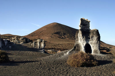 Panoramic view of land and mountain against clear blue sky