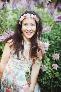 Happy multiracial japanese woman with flower hair band in garden