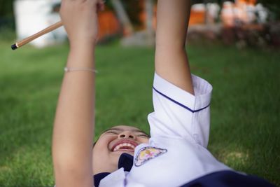 Cheerful girl wearing school uniform while playing on field