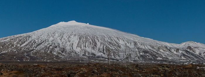 Scenic view of snowcapped mountains against clear blue sky