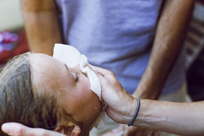 Cropped image of man covering girl's bleeding nose