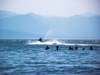 People enjoying in sea against sky