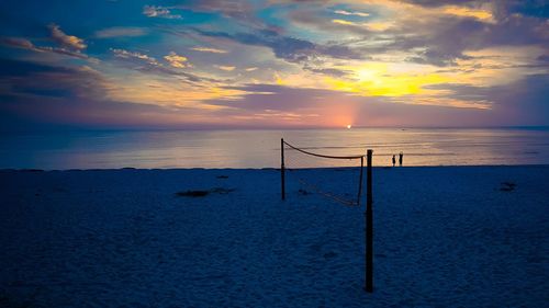 Volleyball net at beach against sky during sunset