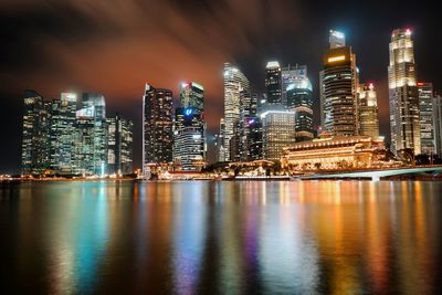 Illuminated buildings in city against sky at night