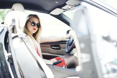 Portrait of young woman sitting in car