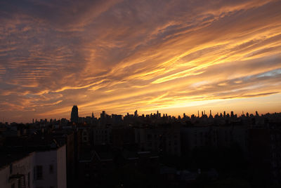 High angle view of silhouette buildings against sky during sunset