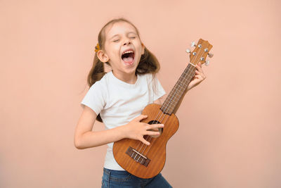 Man playing guitar against wall