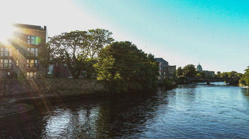 River amidst trees and buildings against sky