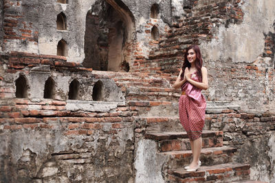 Woman standing against brick wall