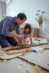 Happy man with daughter installing furniture at home