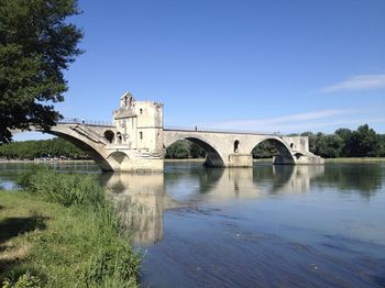 Arch bridge over river against sky