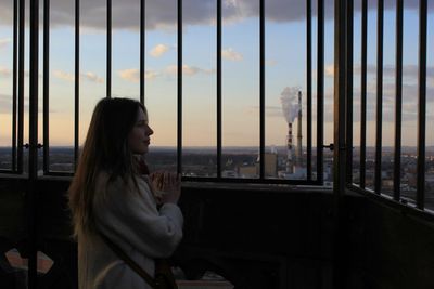 Mid adult man in city against sky during sunset