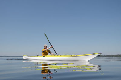 A man on a kayak glides on the surface of the water. water sports theme