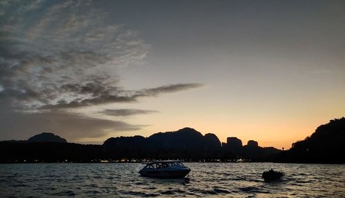 Silhouette boats in sea against sky during sunset