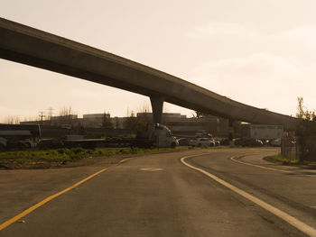 Bridge over road against sky in city