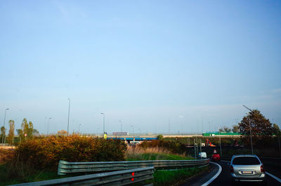 Cars on road in city against clear sky