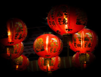 Low angle view of illuminated lanterns hanging at night