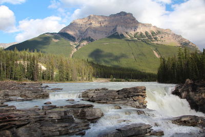 Scenic view of river and mountains against sky