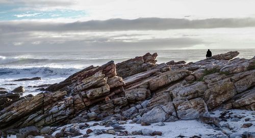 Rock formation on beach against sky