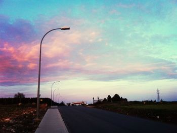 Empty road against cloudy sky