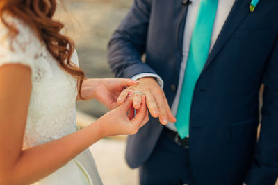 Midsection of couple holding hands