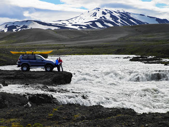 Couple reading map in front of their customised suv in iceland