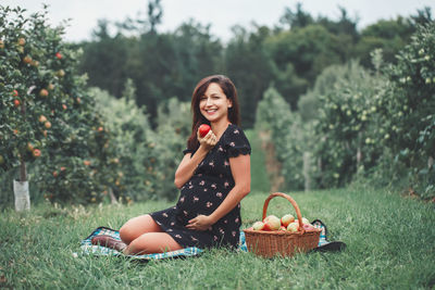 Portrait of smiling young woman sitting in basket