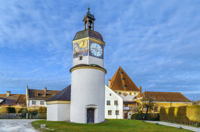 Low angle view of clock tower amidst buildings against sky