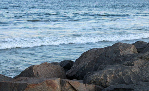 Rock formation on beach against sky