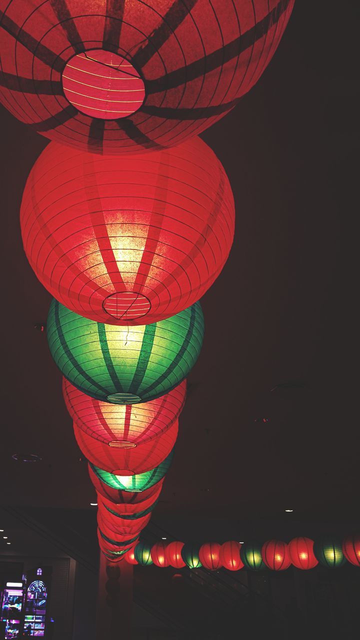 LOW ANGLE VIEW OF ILLUMINATED LANTERNS HANGING FROM CEILING