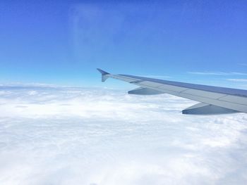 Airplane flying above clouds in sky