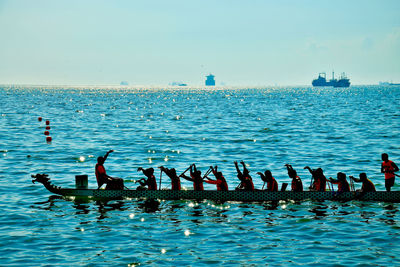 Birds in sea against sky