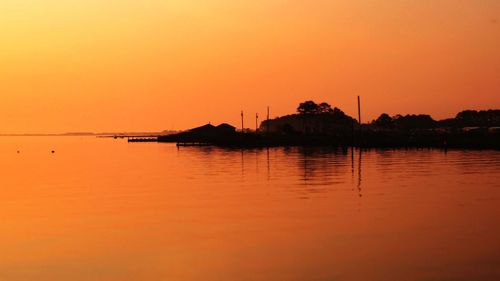 Scenic view of lake against clear sky during sunset