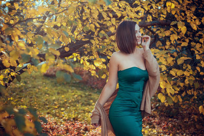 Low section of woman standing on leaves during autumn