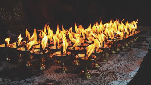 Close-up of illuminated candles in temple