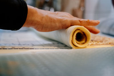 Close up of human hand rolling cake dough