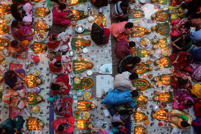 Directly above shot of people with illuminated diyas during religious fasting