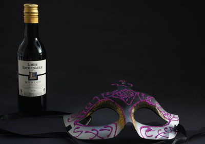 Close-up of wine bottles on table against black background